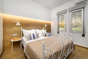 科斯镇Michelangelo City Luxury Lodge的一间卧室设有一张大床和两个窗户。