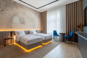 穆卡切沃Villa Boutique Hotel的酒店客房带大床和蓝色椅子