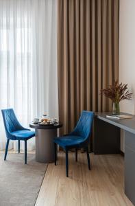 穆卡切沃Villa Boutique Hotel的两个蓝色的椅子和一张桌子