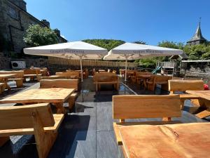 布莱奈费斯蒂尼奥格Grapes Hotel, Bar & Restaurant Snowdonia Nr Zip World的一排桌子和长椅,带雨伞