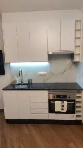 布埃乌Apartamento Centroplaya的厨房配有白色橱柜、水槽和炉灶。