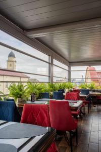 穆卡切沃Villa Boutique Hotel的餐厅设有桌椅和大窗户。