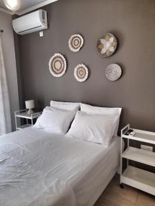 卢特拉艾季普苏Downtown Apartment的卧室配有一张白色床,墙上挂着3个盘子