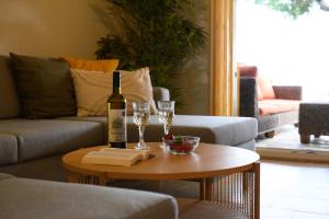 格利法达Seaduced Beachfront Villa by CorfuEscapes的客厅的桌子上放有一瓶葡萄酒和玻璃杯