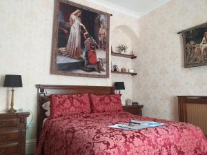 哈佛威斯特St David's Guesthouse的卧室配有红色的床和墙上的绘画