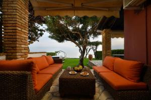 格利法达Seaduced Beachfront Villa by CorfuEscapes的户外庭院配有橙色沙发和桌子