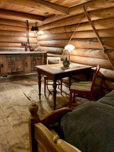 Stabburet på Gaarder / wifi og sauna的木制客房配有桌子和床。