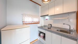 江陵市Eungabi Pension的白色的厨房设有水槽和台面