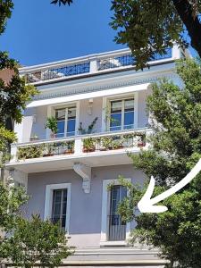 的里雅斯特medium miramare appartamento sogno sul mare的一座白色的建筑,里面装有窗户和植物