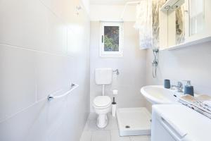 圣安德烈亚Villetta Sant'Andrea - Goelba的白色的浴室设有卫生间和水槽。