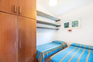 圣安德烈亚Villetta Sant'Andrea - Goelba的一间卧室配有两张床和一个衣柜