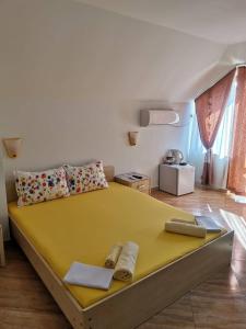 索佐波尔Виктория Созопол的一间卧室配有一张带两个枕头的大型黄色床