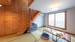 江陵市Eungabi Pension的客厅设有木墙和楼梯。
