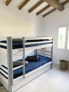 圣马克西姆Villa avec piscine privée的白色客房内的一间卧室配有双层床