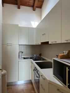 塞拉瓦莱·斯克里维亚Vittoria Apartment的白色的厨房配有白色橱柜和水槽