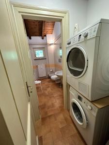 塞拉瓦莱·斯克里维亚Vittoria Apartment的带卫生间的浴室内的洗衣机和烘干机