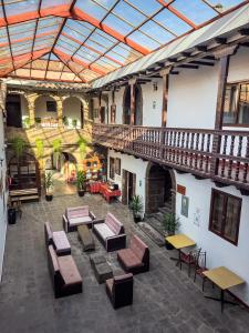 库斯科Hotel Cusco Plaza Saphi的大楼内带桌椅的室内庭院