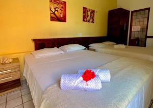 路易斯科雷亚Mansão do Kite - Praia do Coqueiro的两张位于酒店客房的床,上面有红花