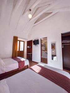 库斯科Hotel Cusco Plaza Saphi的一间酒店客房,设有两张床和电视