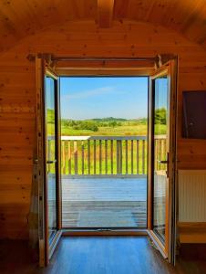 KeltyPond View Pod 3 With Private Hot Tub - Pet Friendly -Fife - Loch Leven - Lomond Hills的小屋的开放式门,享有甲板的景色