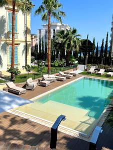 阿拉西奥Alaxia Luxury Apartments的一个带躺椅的游泳池,棕榈树