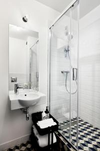 华沙Bez Kantów Art Rooms的白色的浴室设有水槽和淋浴。