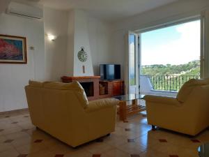 伊斯基亚Villetta Panoramica的客厅配有两把椅子和电视