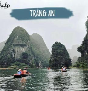 宁平Ninh Bình gest house的一群人乘着船在一条有山的河上