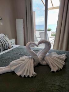 阿齐欧斯·贡多斯Nereides Apartments的两个天鹅在床上心跳