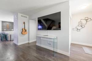 斯科茨Desert Palms Hangout的白色的客房设有一张桌子和墙上的吉他