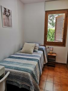 卡莱利亚德帕拉弗鲁赫尔Apartamento con piscina L' Áncora的一间卧室设有一张床和一个窗口
