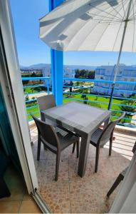 卡博尼格洛Lovely Apartment in CABO, RIVIERA BEACH的阳台配有桌椅和遮阳伞