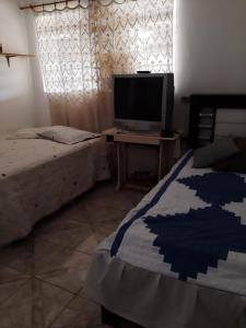 皮拉西卡巴Chacara Oliva的一间卧室配有一张床和一张桌子上的电视