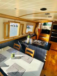 利物浦Lovely 2-Bedroom Barge Brunswick Dock Liverpool!的船上的厨房配有桌椅
