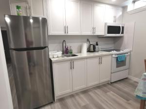米西索加Perfect location comfort private house lower level 2 bedroom unit的厨房配有白色橱柜和不锈钢冰箱