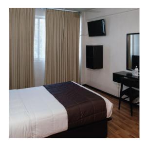 克雷塔罗姆帕拉魁塔和酒店的酒店客房配有一张床、一张书桌和一台电视。