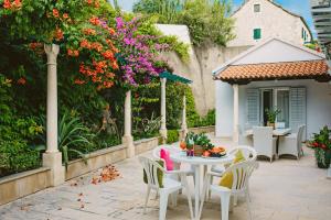 波尔Villa Ardura - island holiday residence **** Bol. Island Brač的庭院配有桌椅和鲜花