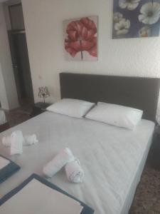 佩科霍里PELEKAN rooms and apartments Athina 33的一张白色的床,上面有两条可移动的毛巾