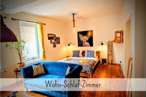 于尔岑Uhlpartment - Romantisches Apartment im Zentrum的一间卧室配有一张床和一张蓝色的沙发