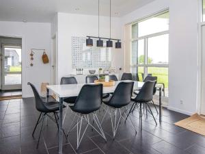 哈泽斯莱乌Holiday home Haderslev L的一间配备有白色桌子和黑色椅子的用餐室