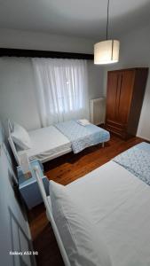 卡瓦拉Madeline house的一间卧室配有两张床和吊灯。