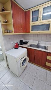 卡瓦拉Madeline house的厨房配有洗衣机和水槽