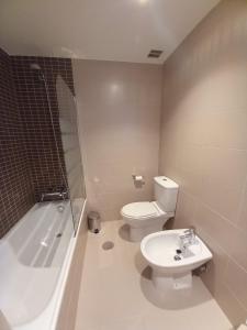 比利亚维西奥萨Apartamento Aurora的浴室配有卫生间、浴缸和水槽。