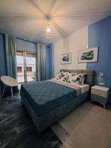 尼坡帝Gala Premium的一间卧室配有一张带蓝色墙壁的大床