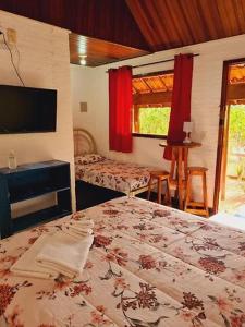 圣代佩德罗Quintal das Estrelas的一间卧室配有一张床和一台电视。