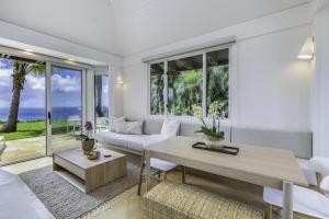 KilaueaHale Nanea home的客厅配有沙发和桌子