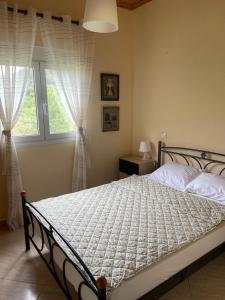 阿莫利亚尼岛Villa Alexandros的一间卧室配有床和带窗帘的窗户