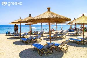尼坡帝Gala Premium的海滩上的一组椅子和遮阳伞