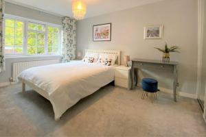 红山Redhill Town Centre 3 bed House near Gatwick Airport, easy commute to London的卧室配有一张白色大床和一张书桌