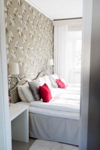 MauritsbergMauritzbergs Slott & Golf的卧室配有带红色枕头的白色床